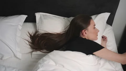 Front view of shocked young pretty woman oversleep and getting up fast while Video stock 148352240