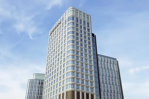 Front view of skyscraper with numerous windows against a clear blue sky Stock Photos