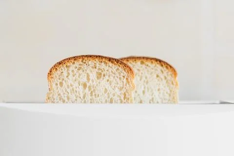 Front view on sliced fresh bread inserted into a white toaster, selective soft Stock Photos