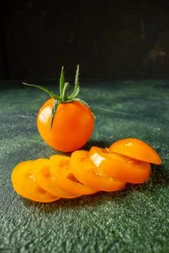 Front view sliced orange tomatoes on dark green background fruit vegetable .. Stock Photos