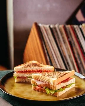 A front view sliced toasts with vegetables pieced inside yellow table on th.. Фото