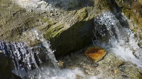Front view of small waterfall, water surface flows over rocks Stock Footage 152359265