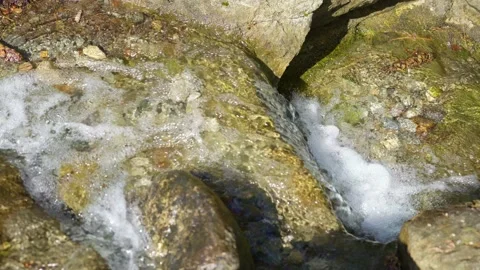 Front view of small waterfall, water surface flows over rocks Stock Footage 152359378