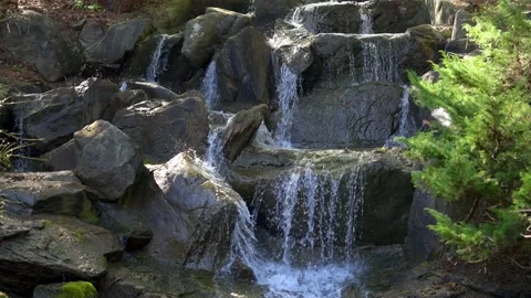 Front view of small waterfall, water surface flows over rocks Stock Footage 152439795
