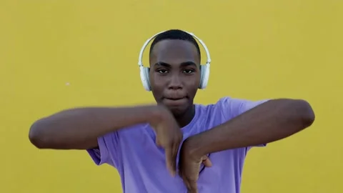 Front view of smiling young african american man in headphones dancing outdoors Stock Footage 212882277