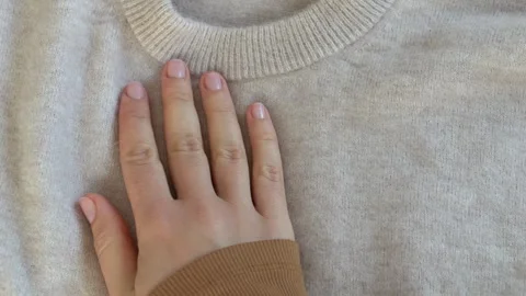 Front view of soft beige sweater highlighting structure and comfort. Ideal for Stock Footage 332875802
