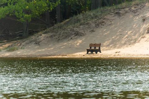 Front view of a solitude bench over looking water on a sandy beach Foto stock