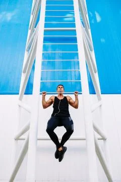 Front view of sportive man pulling-up outdoors Stock Photos