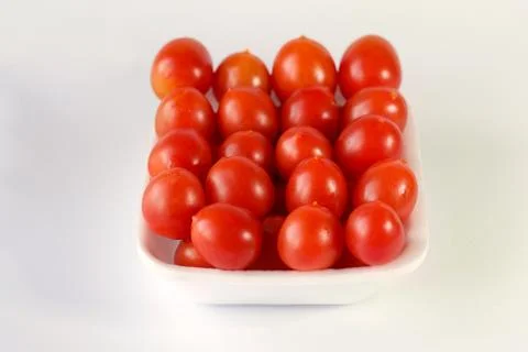 Front view of a stack of red cherry tomatoes, close up. Stock Photos