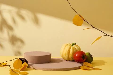 Front view of stack of round brown podiums with yellow autumn leaves branch o Stockfoto's