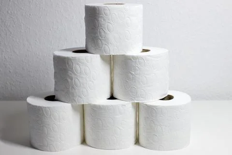 Front view of stacked rolls of soft white toilet paper forming a triangle s.. Stock Photos