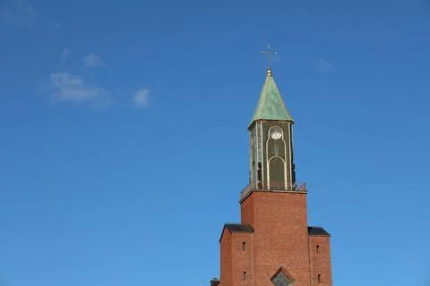A front view of Stora kyrkan, a large red brick church with a prominent clock Stock Photos