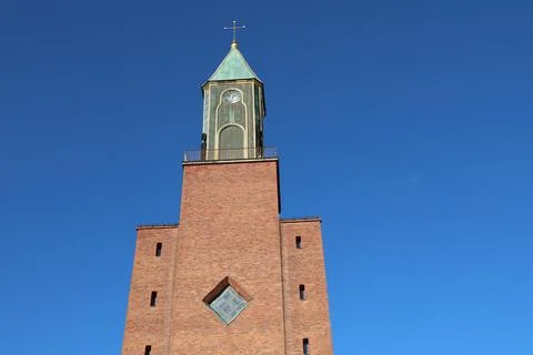 A front view of Stora kyrkan, a large red brick church with a prominent clock Stock Photos