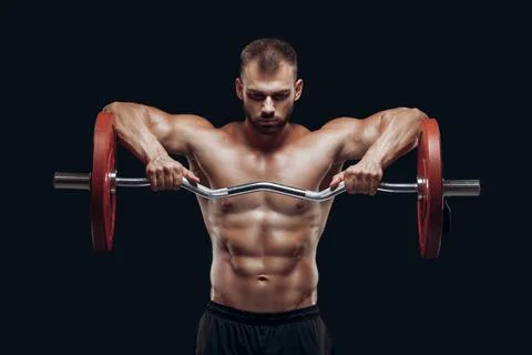 Front view of a strong man bodybuilder lifting a barbell isolated on black Stock Photos