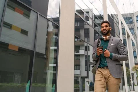 Front view of student walking in front of building outdoors in city. Fotos de archivo