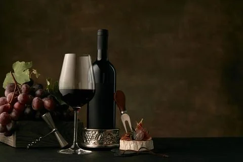 Front view of tasty fruit plate with the wine bottle on dark studio backgroun Stock Photos