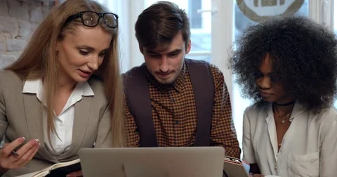 The front view of the three multi-ethnic businesspeople having fun while working Stock Footage 84041220