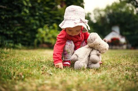 A front view of toddler girl outdoors in garden in summer. Stock Photos