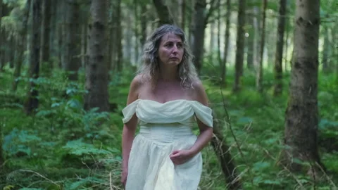 Front View Tracking Shot of Caucasian Woman in White Dress Walking Through Fores Stock-Footage 337897714