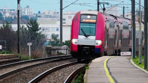 Front view of train approaching camera on railway tracks with city building.. Stock Footage 339380327