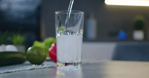 Front view of transparent glass that is filled with fresh water on the kitchen Stock Footage 148737208