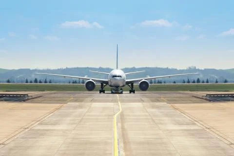 Front view of a twin engine big jet plane on an airport taxiway Stock Photos