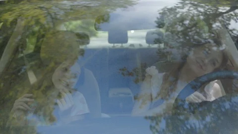 Front view of two joyful girls enjoying music voming heads to the sides sitting Video stock 112749020