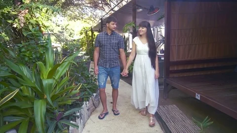 Front view of two lovers walking on the seaside and holding hands Stock Footage 72110551