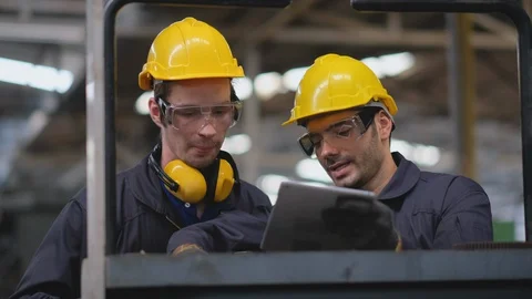 Front view of two technicians or workers try to learn how to operate machine. Stock Footage 127818853