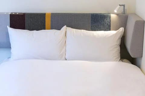 Front view of two white pillows on a made bed in hotel Stock Photos