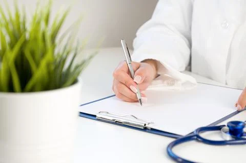 Front view at unrecognizable doctor using calculator with laptop and stethosc Stock Photos