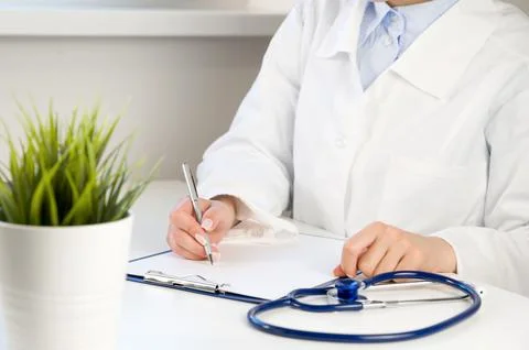 Front view at unrecognizable doctor using calculator with laptop and stethosc Stock Photos