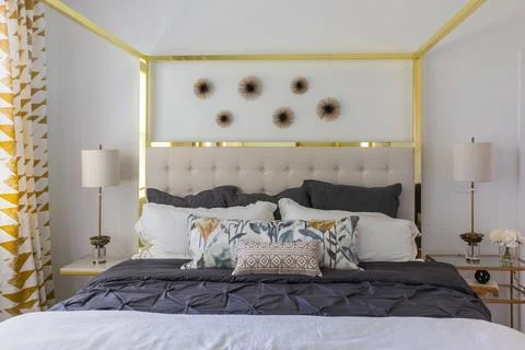 Front view of upholstered headboard bed with brass overhead frame Stock Photos