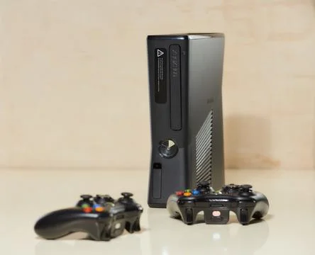 Front view of the used XBOX 360 Slim (Corona) 250GB Console and two gamepads Stock Photos