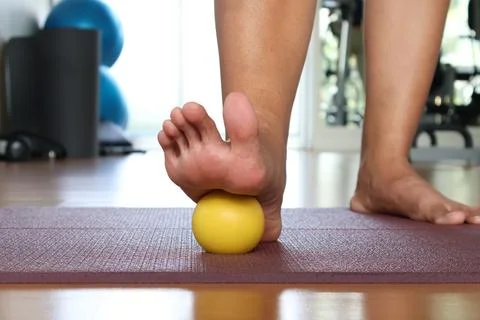 Front view using foot massage ball to relieve Plantar fascia on yoga mat. Foto stock