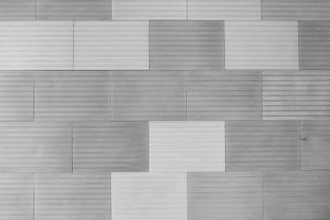 A front view of wall, decorated with gray tiles with relief Stock Photos
