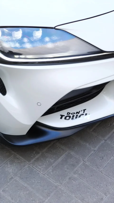 Front view of white aggressive sports car with protective warning sticker Stock Footage 337615646