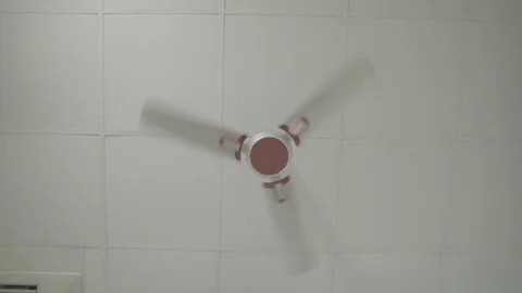 Front View of White blades and red centered Ceiling Fan - Shot on Sony FS7 Stockbeeldmateriaal 91173977