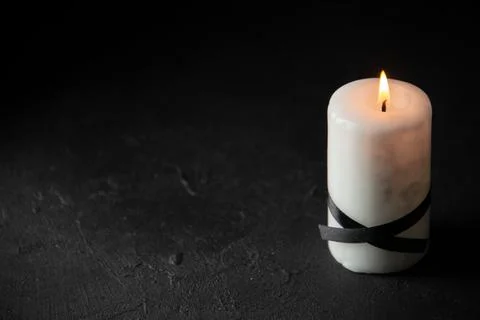 Front view of white candle on dark desk death evil genocide mourn war tank .. Stock Photos