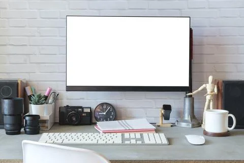 Front view white empty computer screen, camera, coffee cup and supplies on .. Stock Photos