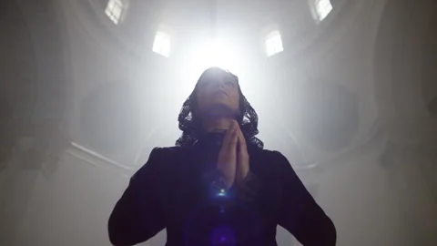 Front view of a woman in black praying Stock Footage 283244853