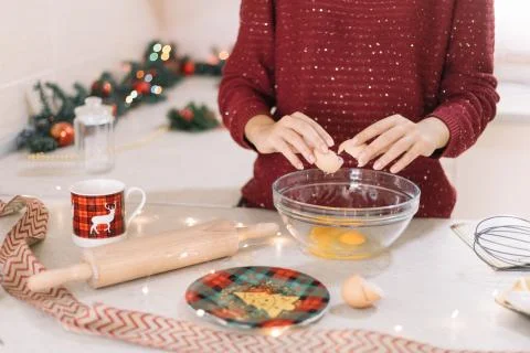 Front view of womans hands cracking egg into a bowl Stock Photos
