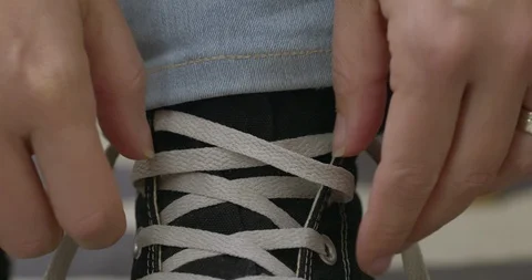 Front view woman's hands tie white laces on running shoe 4K Stock Footage 121135104
