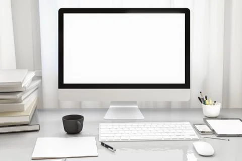 Front view of workpark with blank white computer screen, coffee cup, and book in Stock Photos