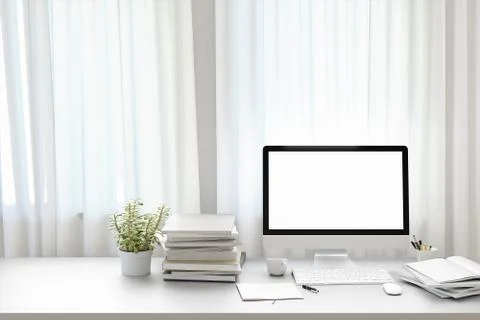 Front view of workpark with blank white computer screen, coffee cup, and book in Stock Photos