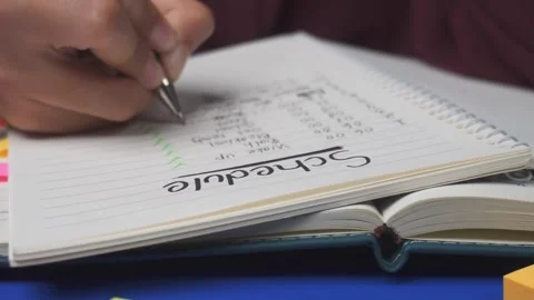 Front view of writing daily routine schedule on book Stock Footage 276826599