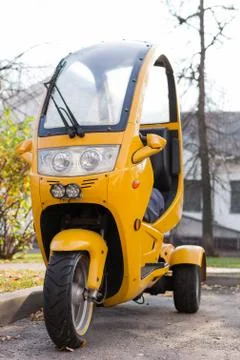 Front view of yellow three wheels cabin motorcycle, headlight Stock Photos