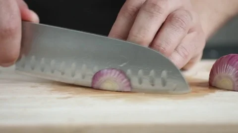 Front view of yong man cook cut thin slices of red onion with knife on cutting Stock Footage 74345308