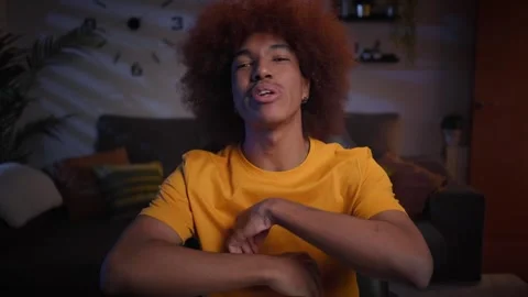 Front view young afro man influencer doing video tutorial sitting in living room Vídeos de archivo 249421515