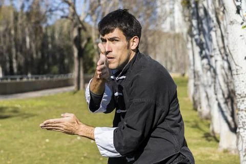 Front view of a young athletic martial arts fighter practicing kicks in a p.. Stock Photos